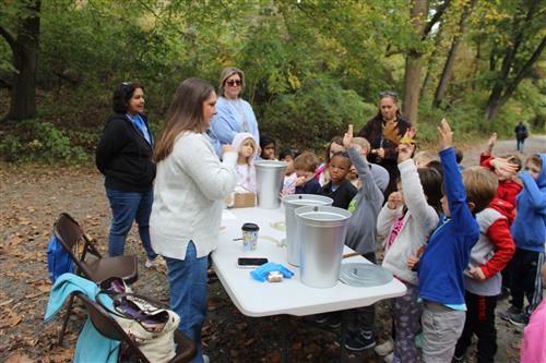 Children gather around table for a demonstration